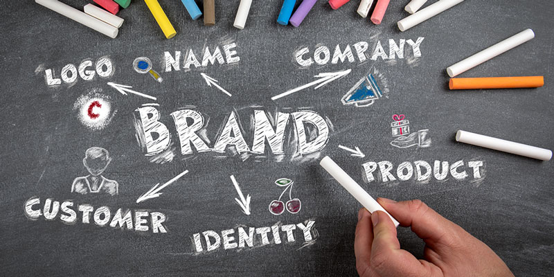 Advertising terms written on chalkboard with multiple chalk sticks around them.