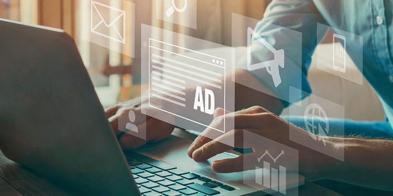 Expert works on laptop creating digital advertising strategy for business.