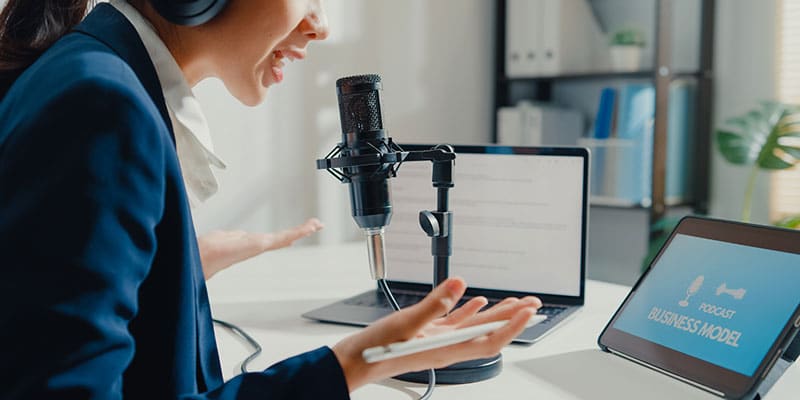 Female voice artist records radio advertising spot in booth.