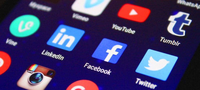 Social media icons on a bright phone screen.